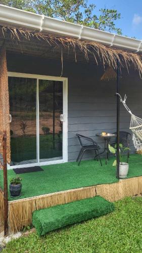 a house with a patio with a table and a chair at CyKali Garden Bungalows in Wok Tum