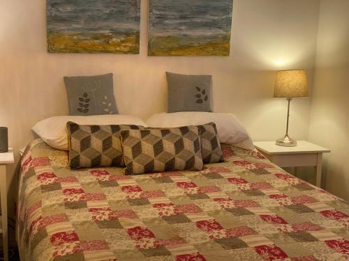 a bedroom with a bed with a quilt on it at Morgraig in Cardiff