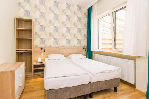 a bedroom with a large bed and a window at 3 WIOSŁA Brzozowa Zatoka in Brenno