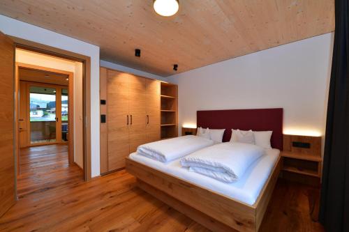a bedroom with a large bed with a wooden headboard at Straußberghof in Riezlern