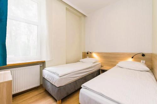 two beds in a small room with a window at 3 WIOSŁA Brzozowa Zatoka in Brenno