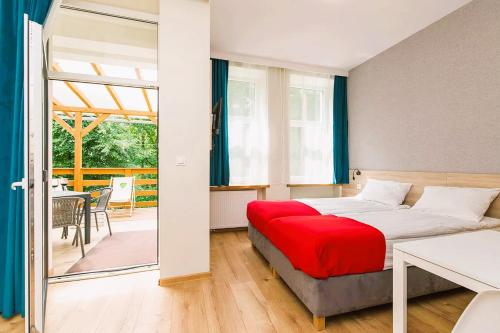 a bedroom with a bed with a red blanket at 3 WIOSŁA Brzozowa Zatoka in Brenno