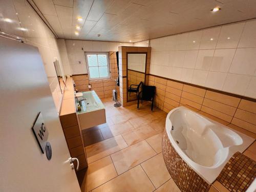 a large bathroom with a tub and a sink at Bungalow by Zimmervermietung K.Krause in Lengede