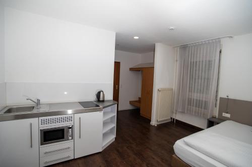 a small kitchen with a sink and a bed at Hotel am Schillerplatz in Pleidelsheim