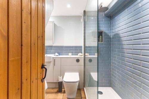 a bathroom with a toilet and a glass shower at Little Braybrooke Cottage- Saffron Walden in Saffron Walden