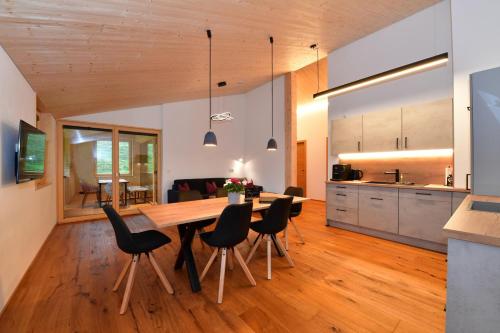 a kitchen and dining room with a wooden table and chairs at Straußberghof in Riezlern