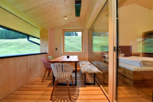 a room with a bed and a table and chairs at Straußberghof in Riezlern