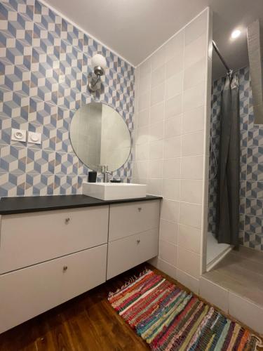 y baño con lavabo y espejo. en Appartement Cosy sous les toits, en Pont-d'Ain