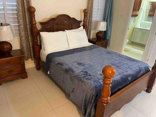 ein Schlafzimmer mit einem Bett mit einem Holzrahmen und zwei Nachttischen in der Unterkunft Oasis @ Richmond Estate - Ocho Rios - St Ann in Richmond