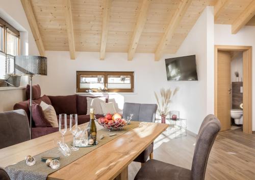 a dining room and living room with a wooden table at Am Dorfbrunnen in Oetz