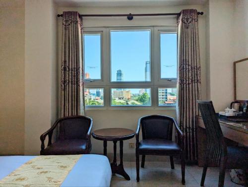 a bedroom with two chairs and a desk and a window at 中青秋果酒店 True Go Hotel in Phnom Penh