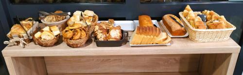a table topped with baskets of bread and baskets of bread at Logis Hôtel - La Chambre d'Amiens in Amiens