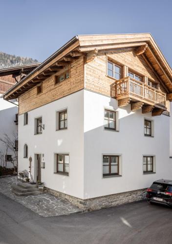 a large white house with a wooden roof at Am Dorfbrunnen in Oetz