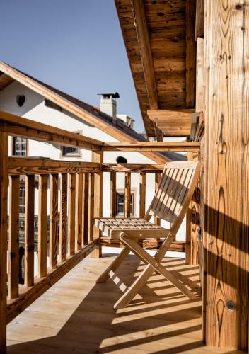 a wooden deck with a chair sitting on it at Am Dorfbrunnen in Oetz