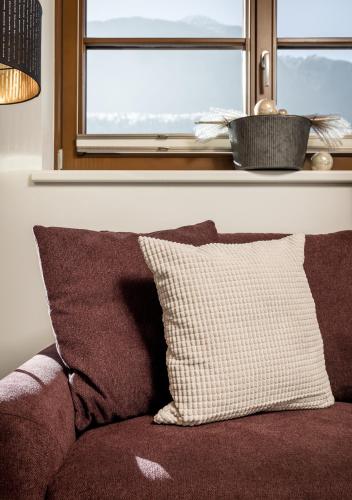 a couch with a pillow sitting under a window at Am Dorfbrunnen in Oetz