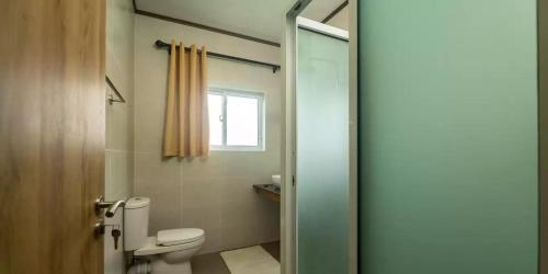 a bathroom with a toilet and a window at Maison Dora in Victoria