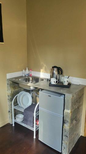 a kitchen with a counter with a sink and a dishwasher at CyKali Garden Bungalows in Wok Tum