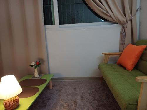 a living room with a green couch and a window at With us house in Ansan