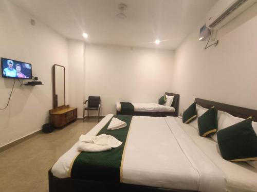 アムリトサルにあるhotel city, Star Hotels & Resorts, Amritsarのベッドルーム1室(ベッド2台、薄型テレビ付)