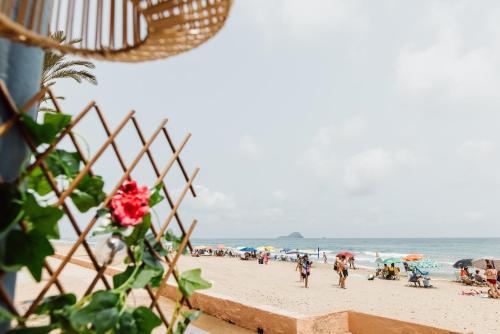 a group of people on a beach with umbrellas at Hotel Apartamentos Londres La Manga in La Manga del Mar Menor