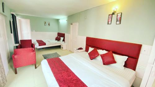 sypialnia z dużym łóżkiem z czerwonymi poduszkami w obiekcie Hotel Himalayan Meadows w mieście Manāli