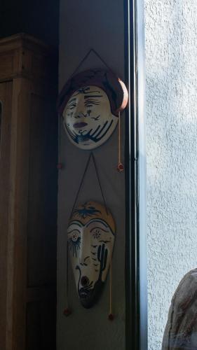 two masks hanging on a wall in a room at Casa de Huéspedes La Azul in Los Árboles