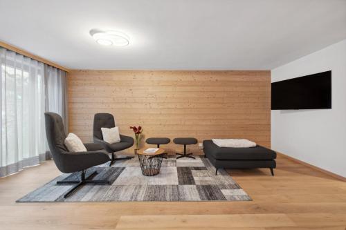 a living room with two chairs and a flat screen tv at Chalet Les Rahâs by Mrs Miggins in Grimentz