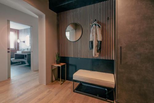 a room with a bench and a mirror on a wall at LA LIBELLA - slow living Suites in Merano