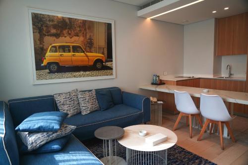 uma sala de estar com um sofá azul e uma cozinha em Monot Suites em Beirute