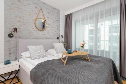 1 dormitorio con cama y mesa con espejo en Gdynia Port Marine Apartment with Sea View by Renters en Gdynia