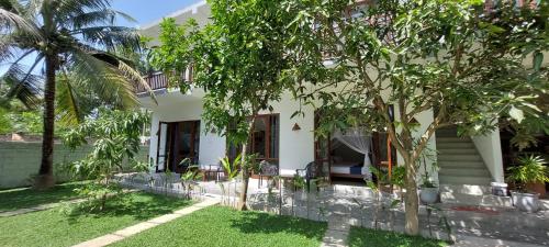 a house with a yard with chairs and trees at Green Grove in Matara
