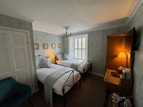 a bedroom with two beds and a window at Brunswick House in Middleton in Teesdale