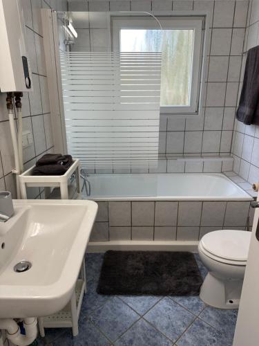 biała łazienka z wanną i toaletą w obiekcie Aminas Ferienwohnung Bad Gandersheim 30/2 w mieście Bad Gandersheim