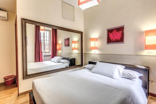 Guest House Trastevere في روما: غرفة نوم بسريرين ومرآة كبيرة