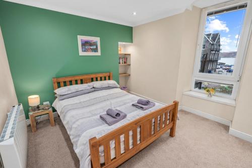 a bedroom with a large bed and a window at Central Stay on Main st- Harbour Views in Oban