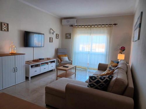 - un salon avec un canapé et une télévision dans l'établissement Casa MANÉ, à Lagos