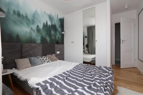 Schlafzimmer mit einem Bett mit Wandgemälde in der Unterkunft Słodowiec Residence II in Warschau
