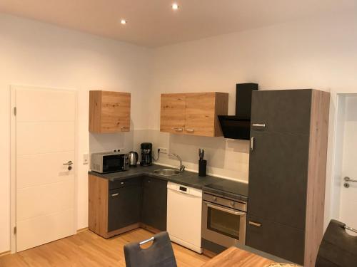 een keuken met een zwarte koelkast en een wastafel bij Mimalou Apartment in Zwickau in Zwickau