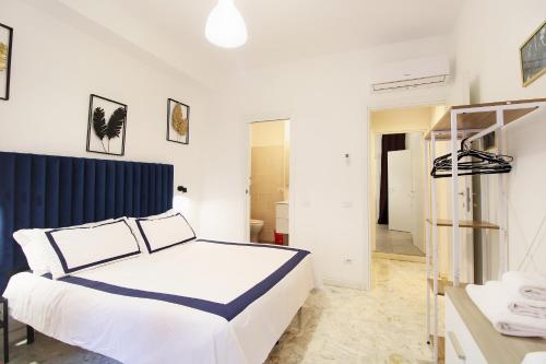 - une chambre avec un lit blanc et une tête de lit bleue dans l'établissement Delicious 2 Bed Room Apartment and Garden by YH, à Rome