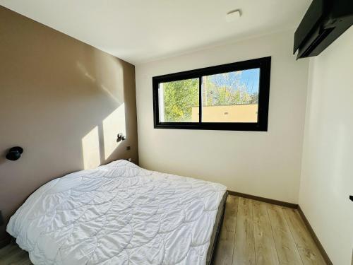 une chambre avec un lit et une fenêtre dans l'établissement L'Oasis de Syam en Provence, à Buis-les-Baronnies