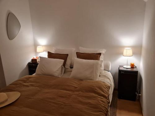 a bedroom with a large bed with pillows and two lamps at Bed vue sur vallée de la Meuse Namur in Bouge