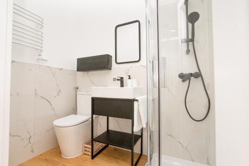 a bathroom with a sink and a shower at Apartamenty Piastowska in Nysa