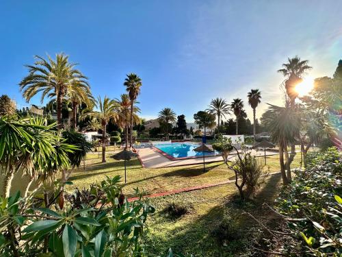 a resort with a swimming pool and palm trees at Casa Caracol in La Herradura