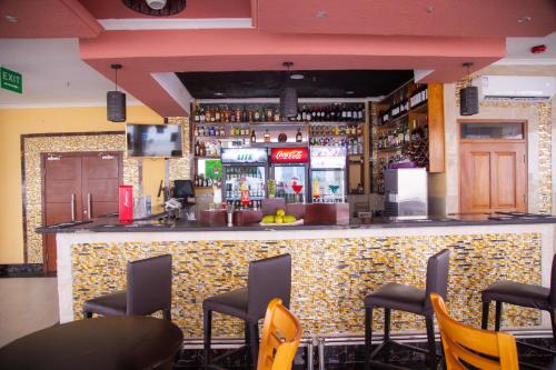 a bar in a restaurant with chairs around it at Tiffany Diamond Hotels LTD - Makunganya in Dar es Salaam