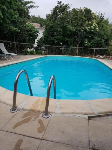 une grande piscine bleue dans une cour dans l'établissement Sigean - Maison domaine viticole, 6 km de la mer, à Sigean