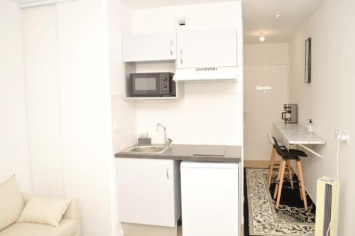 a small kitchen with a sink and a microwave at Cheap Professional Beautiful Studio Apartment in Bobigny