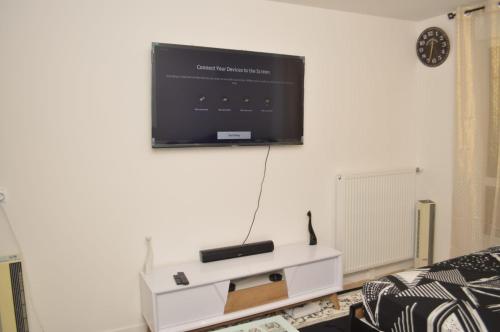 Il comprend un salon doté d'une télévision murale à écran plat. dans l'établissement Cheap Professional Beautiful Studio Apartment, à Bobigny