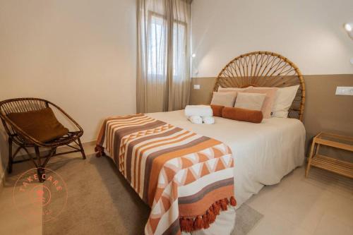 a bedroom with a large bed and a chair at House in fishing village El Palo - TCM in Málaga