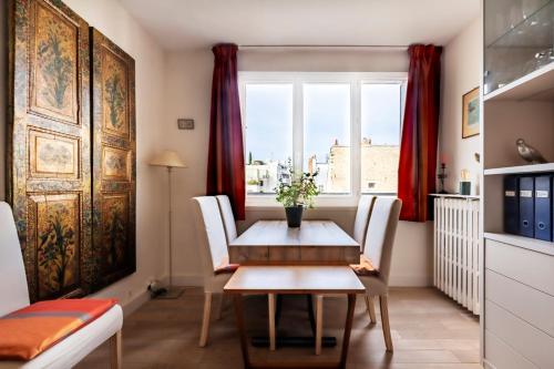 une salle à manger avec une table et une fenêtre dans l'établissement Veeve - Hidden Heaven, à Paris