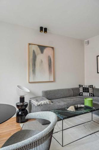 ein Wohnzimmer mit einem Sofa und einem Tisch in der Unterkunft Beautifully decorated apt on the banks of the Seine in Boulogne-Billancourt